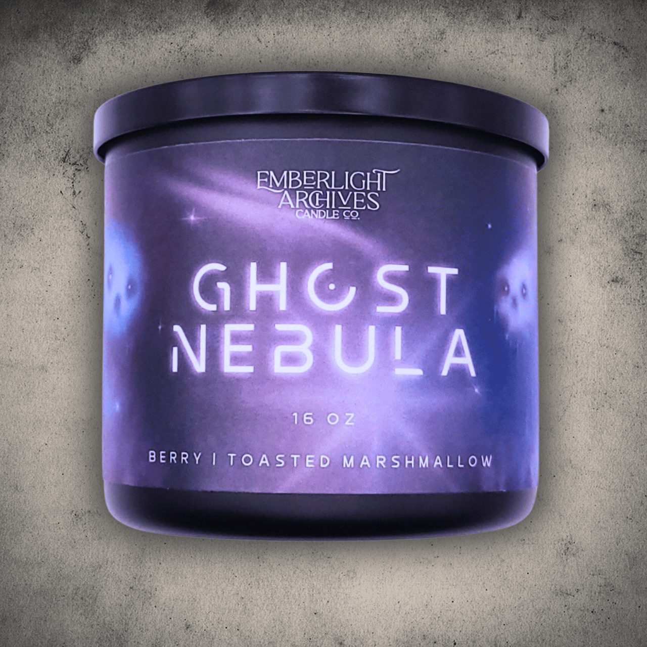 Emberlight Archives Ghost Nebula candle in a 16oz black glass jar with illustrated nebula label against a gray stone background, Berry and Marshmallow scent.